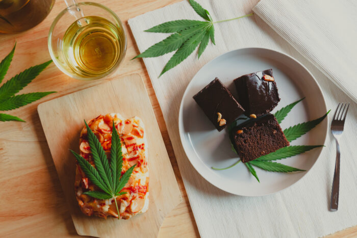 Food and drink and cannabis leaves on the dining table. Alternative medicine concept.