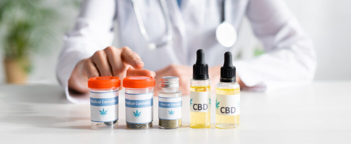 panoramic shot of doctor pointing with finger at bottle with medical cannabis lettering