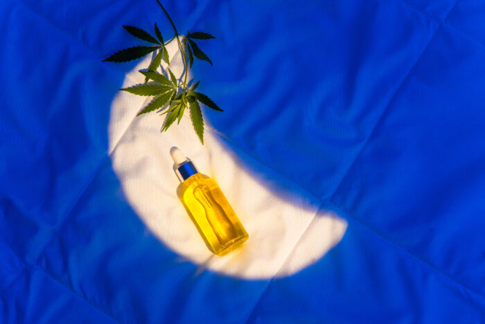 Products on insomnia blanket, cannabis oil tincture, CBD, marijuana leaf